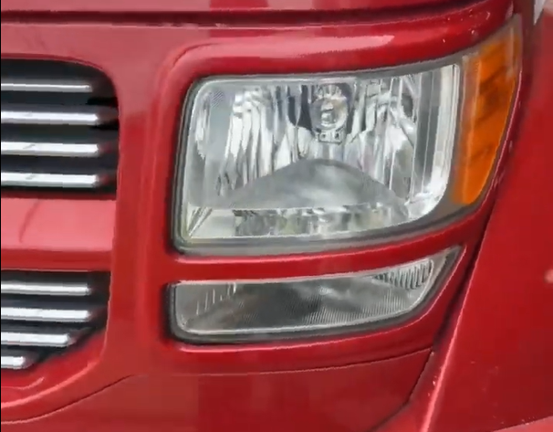 Clear headlight after restoration on a red truck