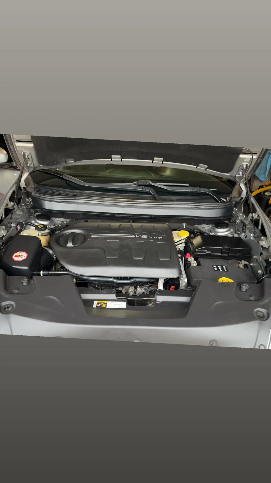 Engine bay after cleanup with plastics and covers restored to a cleaner finish
