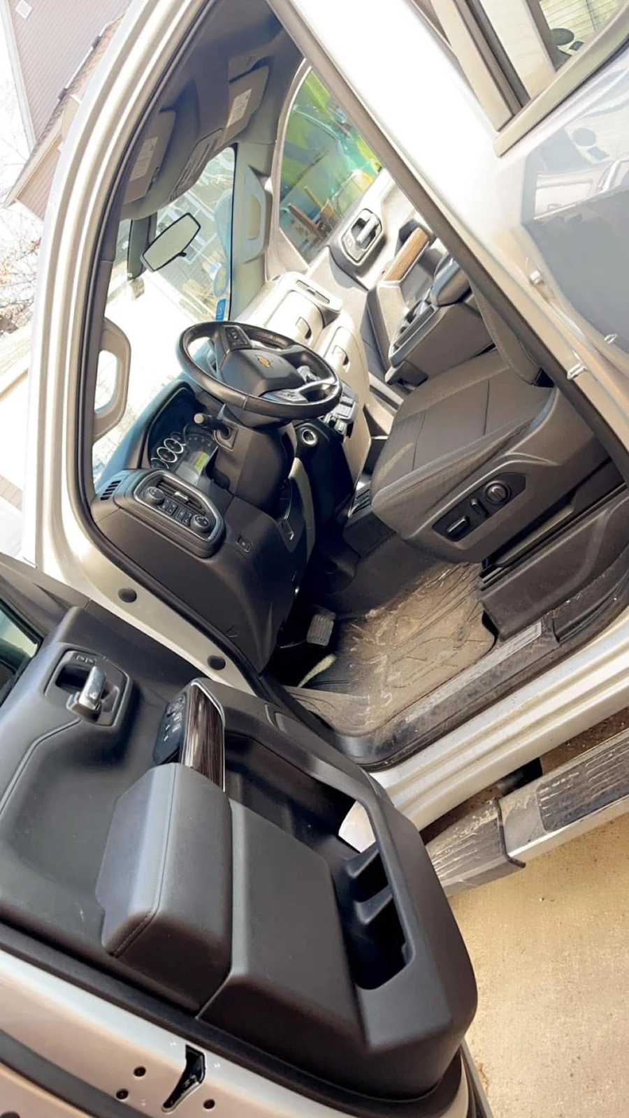 Driver seat area before interior cleanup on a silver pickup