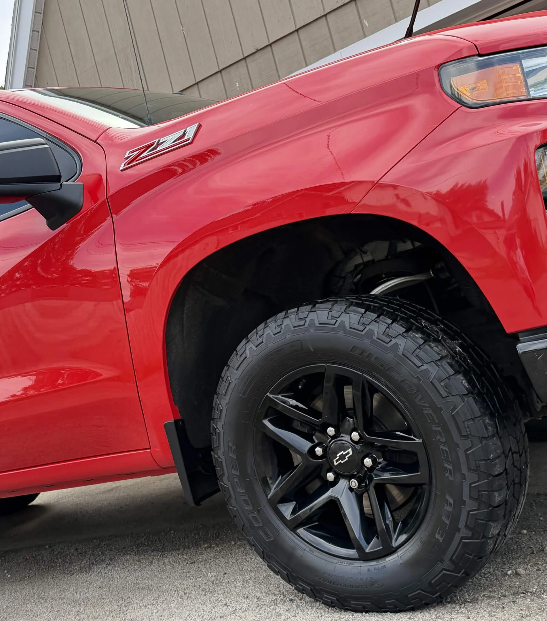 Red pickup after exterior detail with glossy paint, clean wheel, and tire finish